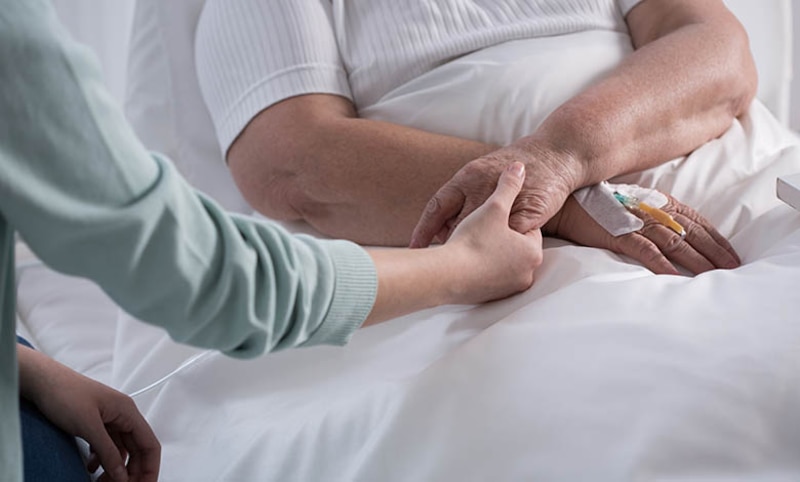 Paciente anciano en cama de hospital