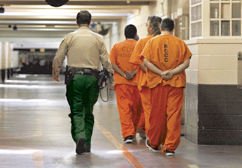 Presos siendo escoltados por un guardia