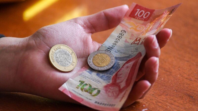 Monedas y billetes en la mano