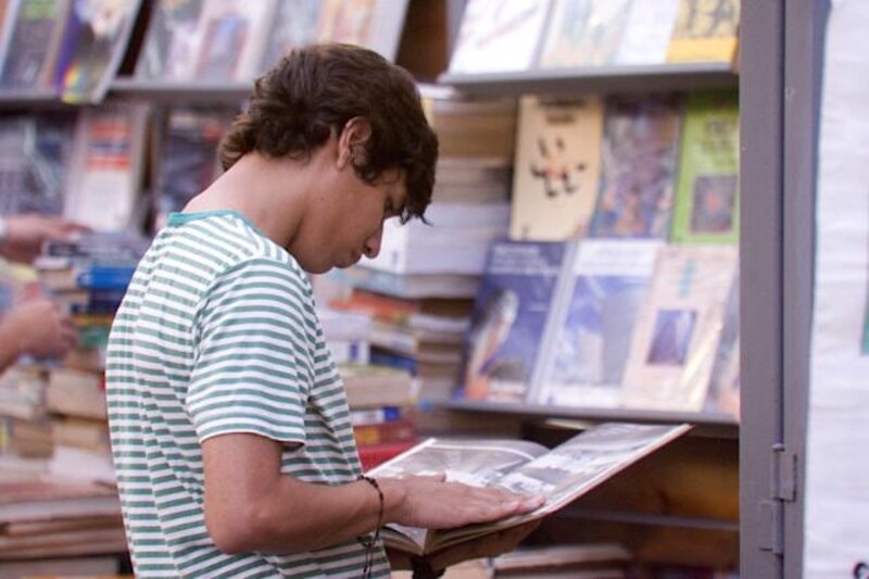 Un joven lee un libro en una librería