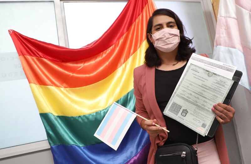 Mujer transgénero sostiene su acta de nacimiento con el nombre y género correctos