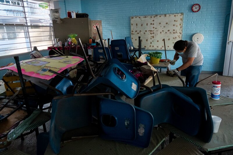 Un hombre limpia un aula en una escuela