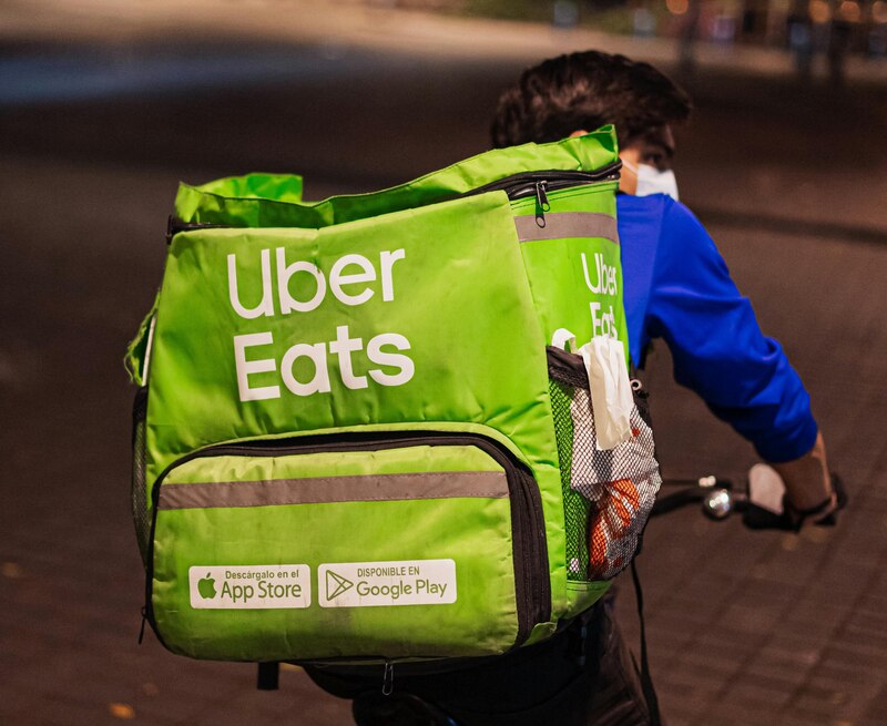 Repartidor de Uber Eats realizando una entrega en su bicicleta