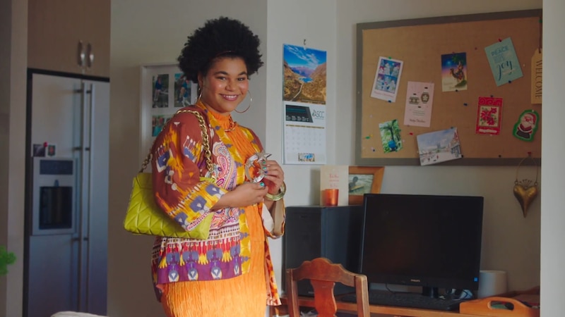 Mujer joven afroamericana sonriendo en la cocina