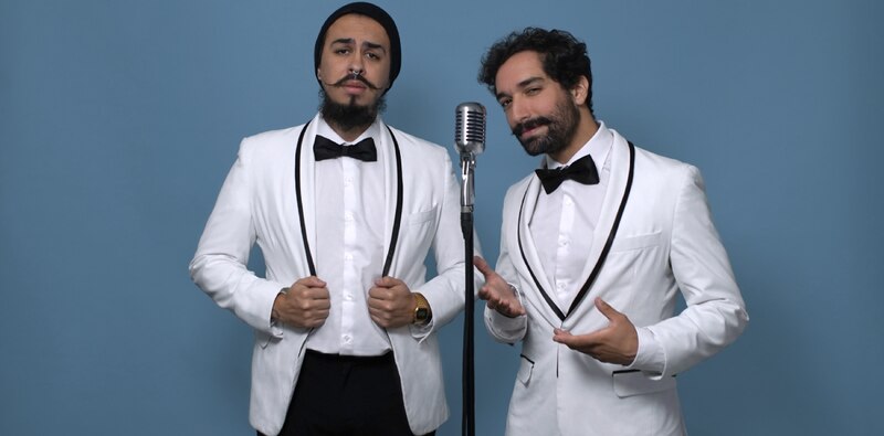 Dos hombres vestidos de blanco con micrófonos
