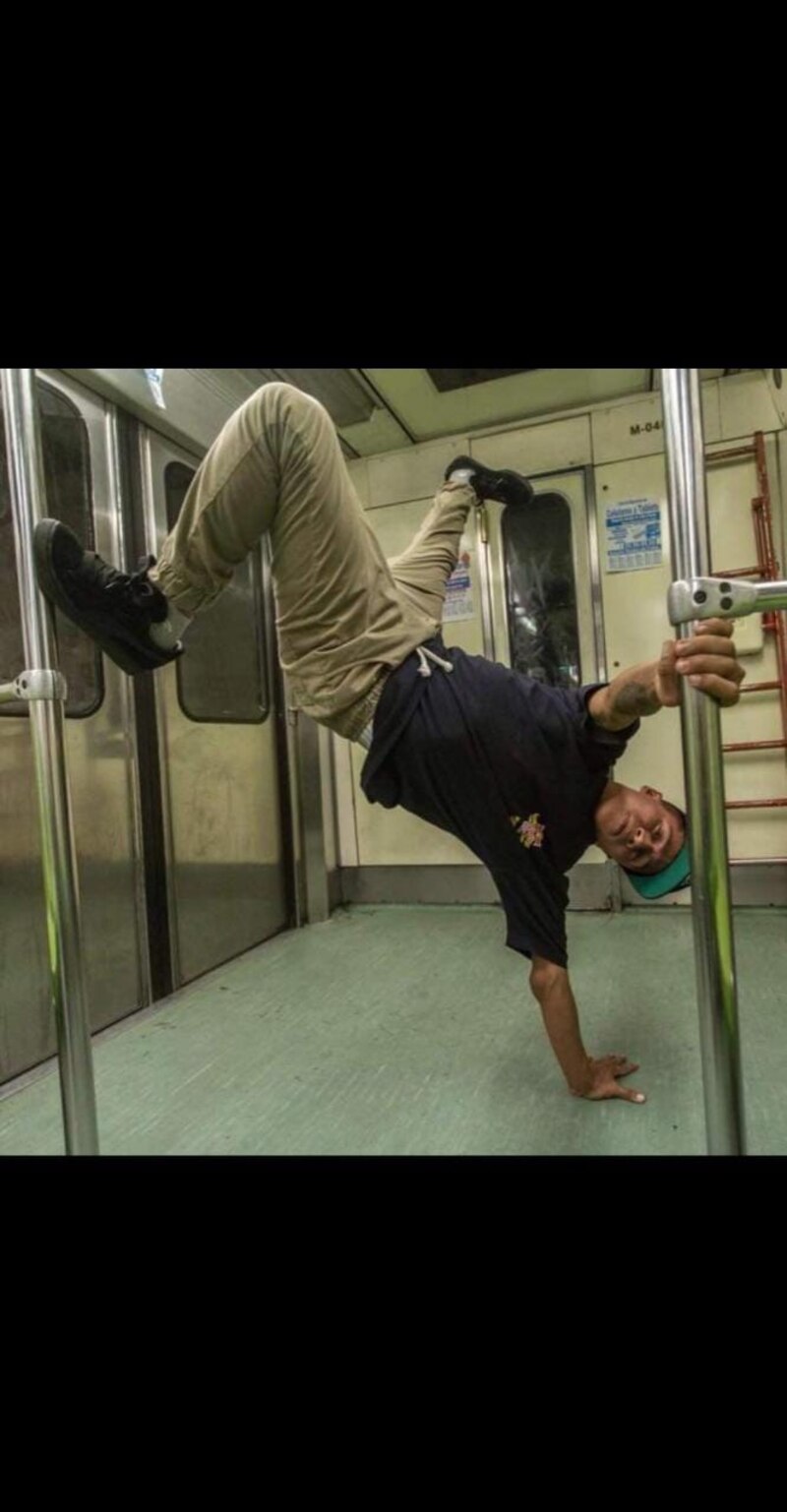 Un hombre haciendo breakdance en un vagón del metro