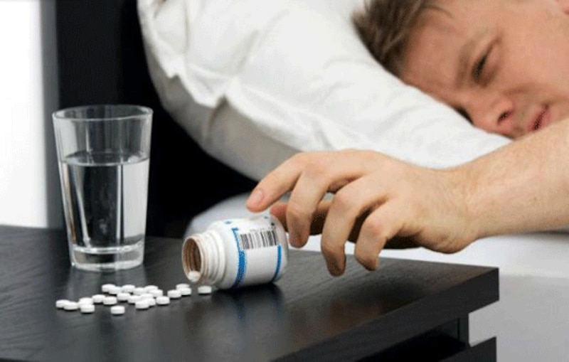 Hombre tomando pastillas para dormir
