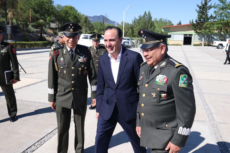 El gobernador de Jalisco, Enrique Alfaro Ramírez, saluda a militares durante un evento público.