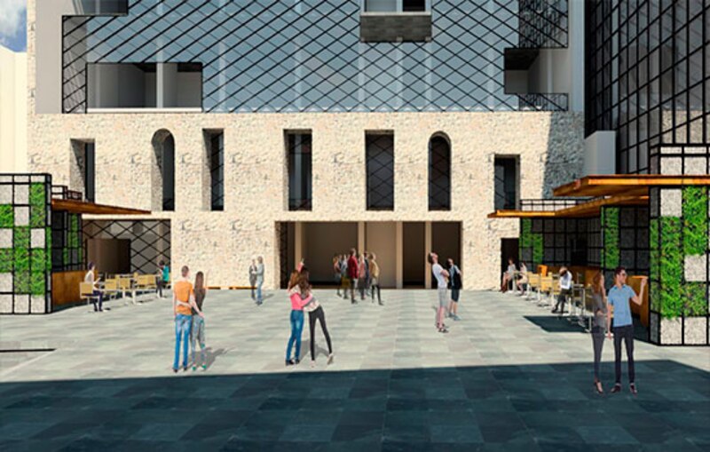 La imagen muestra la fachada de un edificio moderno con un gran ventanal y una puerta de entrada. En la parte delantera hay una plaza con bancos, mesas y sillas, y varias personas paseando.