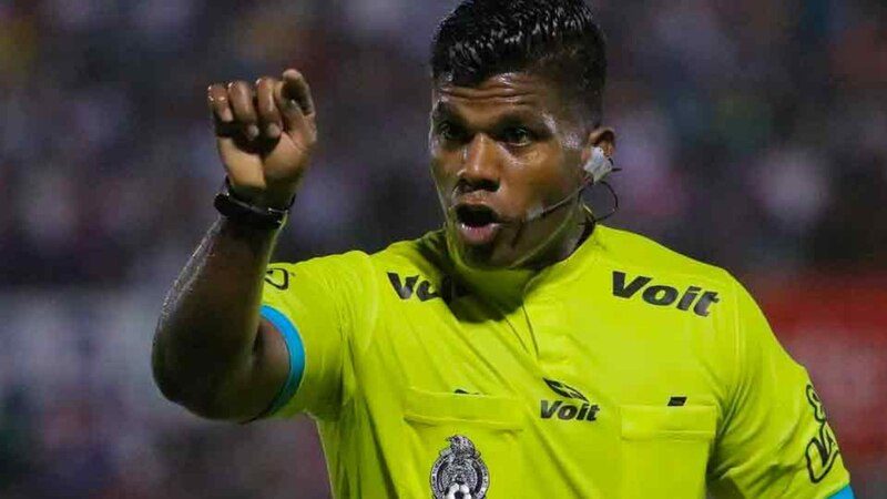 Árbitro de fútbol muestra tarjeta amarilla