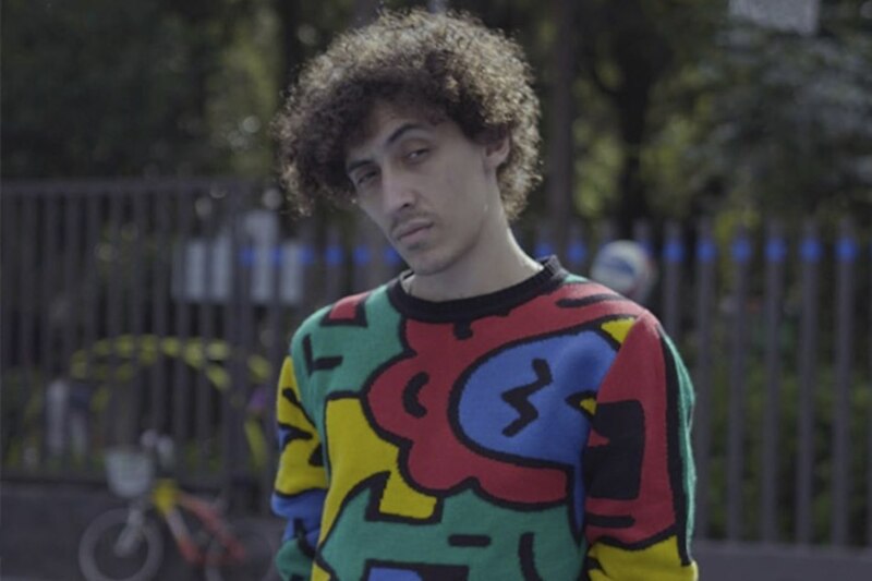 Joven con pelo rizado y jersey colorido