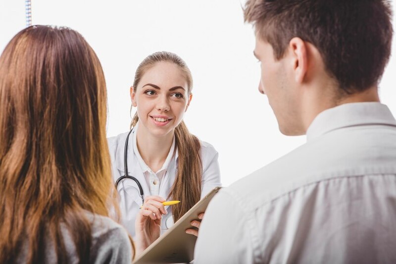 Doctora hablando con una pareja
