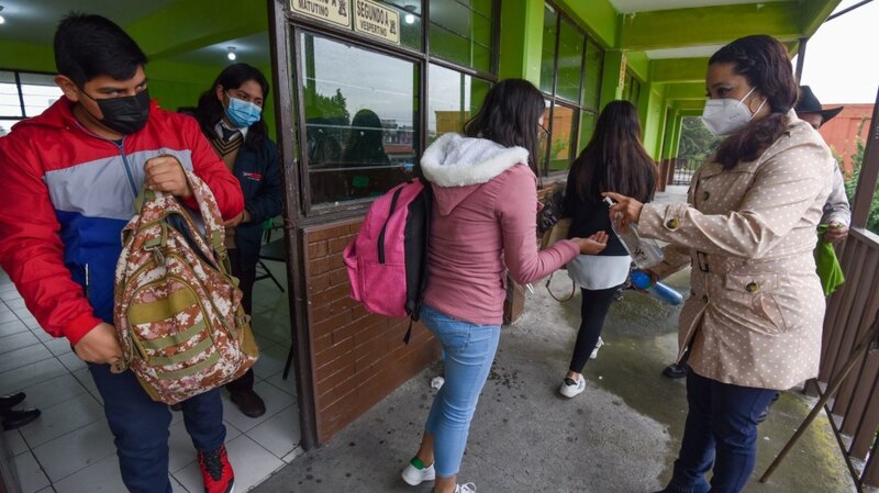 Estudiantes reciben gel antibacterial a la entrada del colegio