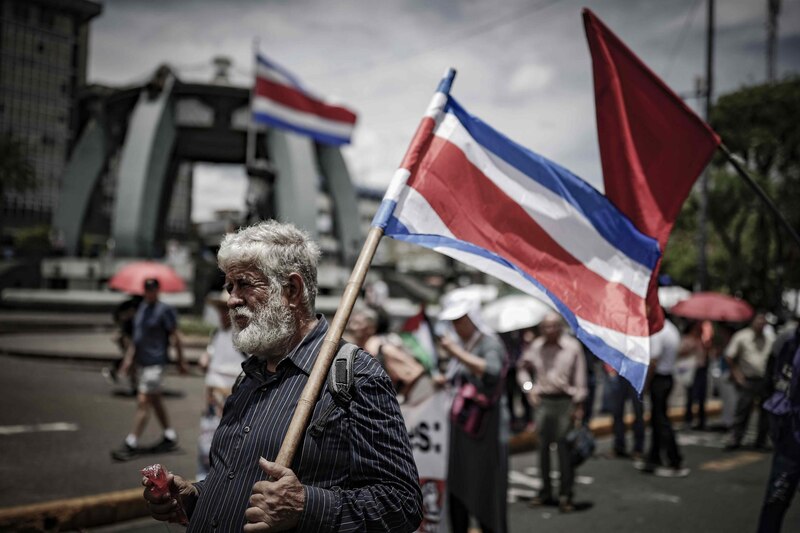 Un hombre sostiene una bandera de Costa Rica