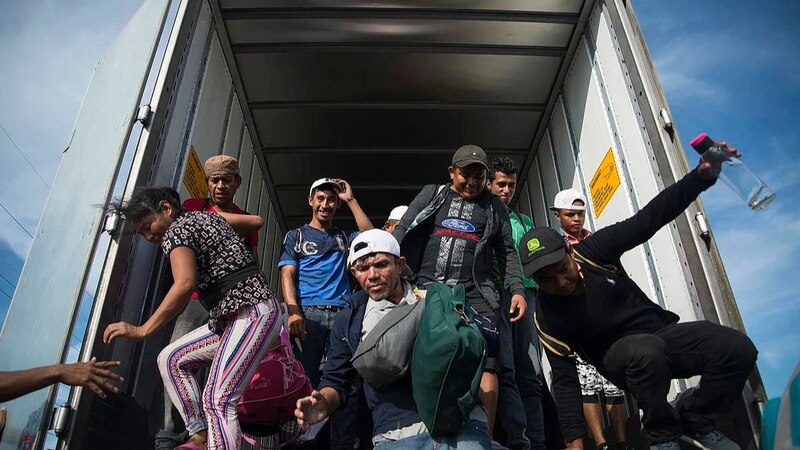 Un grupo de migrantes viaja en la parte trasera de un camión