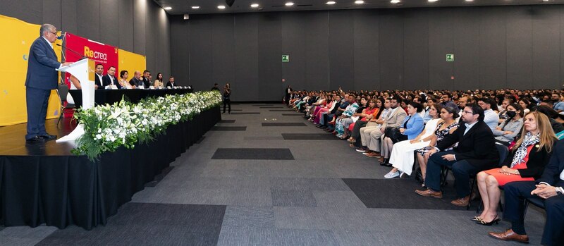 El gobernador da un discurso ante una multitud en un auditorio.