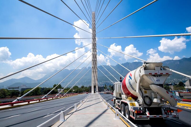 Puente atirantado sobre un río con una montaña al fondo