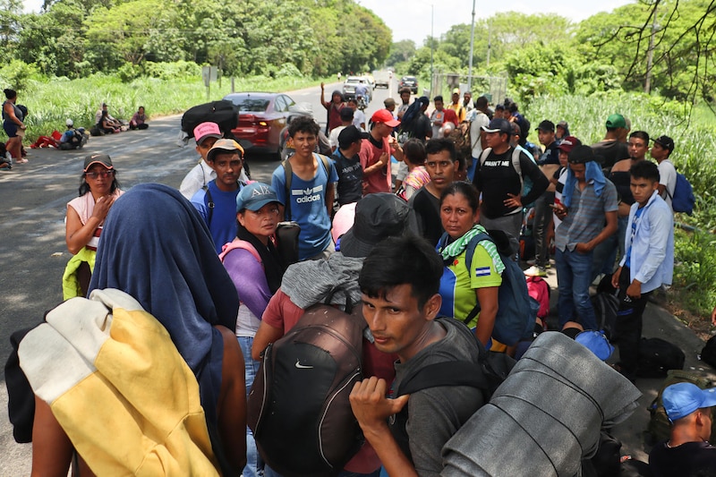 Migrantes venezolanos caminan por una carretera en Colombia