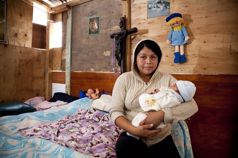 Madre sosteniendo a su bebé en una cama