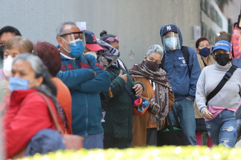 Personas esperan en fila para recibir la vacuna contra el COVID-19