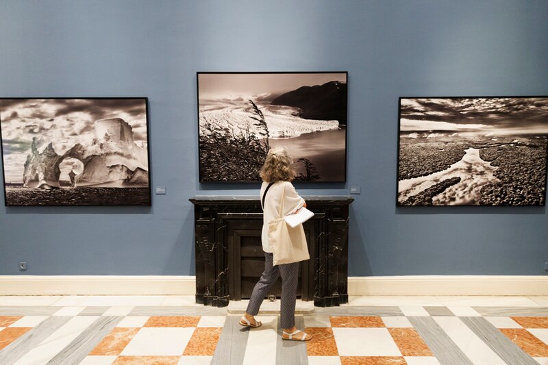 Mujer mirando un cuadro en una galería de arte