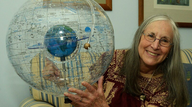 Una mujer sostiene un globo terráqueo.