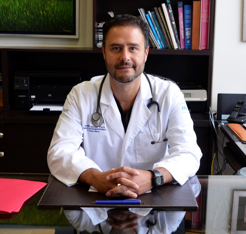 Doctor en bata blanca sentado en su escritorio