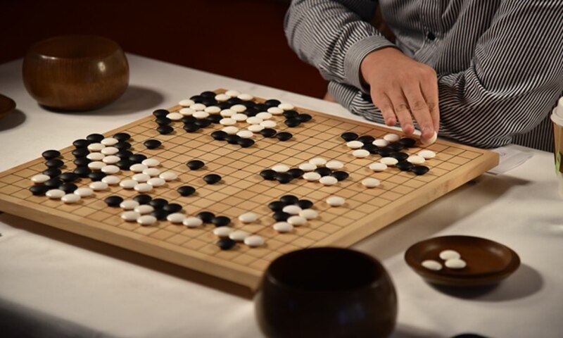 Jugador de Go colocando una ficha en el tablero