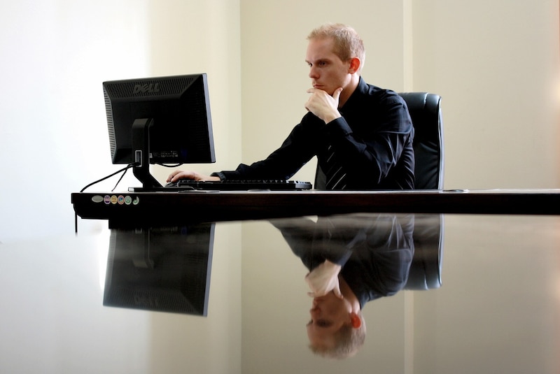 Un hombre sentado frente a una computadora