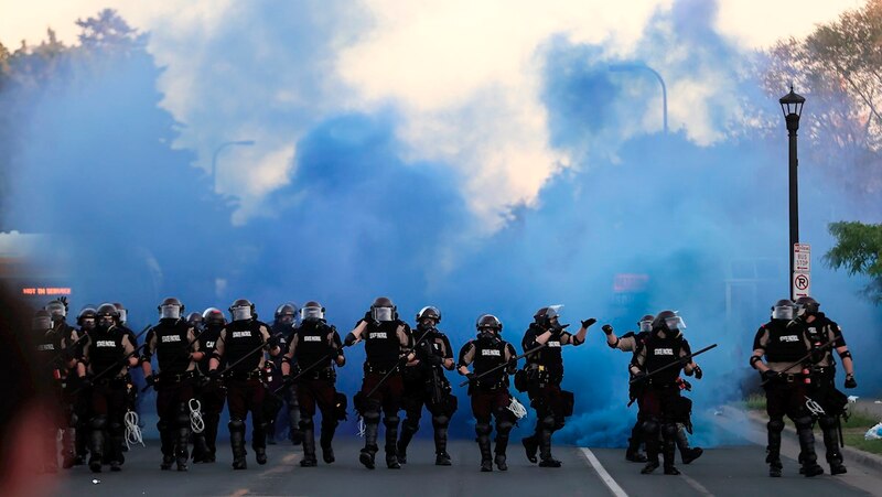La policía antidisturbios se enfrenta a los manifestantes en una calle de Minneapolis