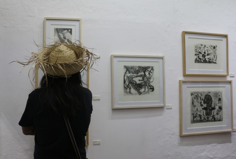 Mujer mirando un cuadro en una galería de arte
