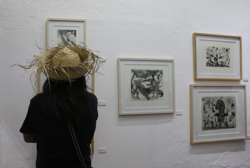 Mujer mirando un cuadro en una galería de arte
