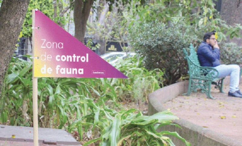 Señal de advertencia sobre el control de fauna en una zona verde