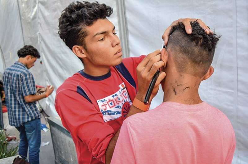 Un joven se corta el pelo en una barbería.