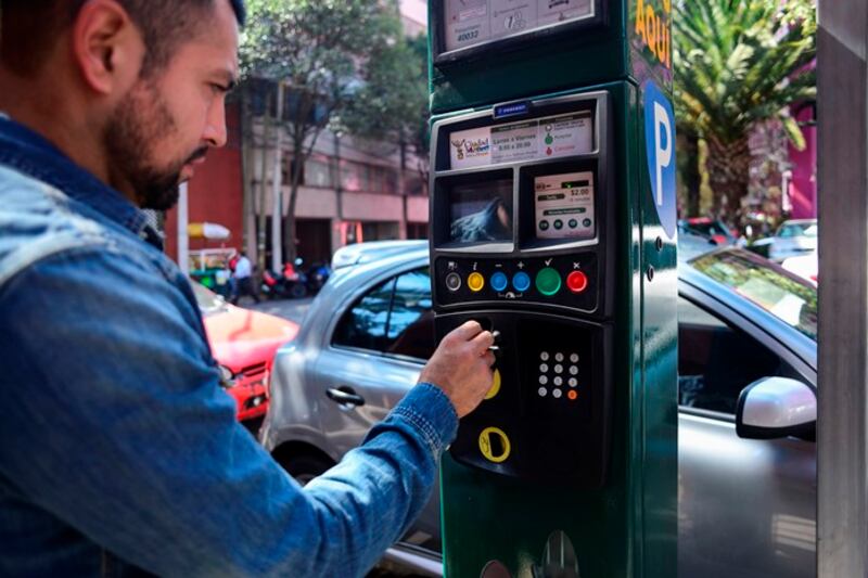Un hombre paga el parquímetro en la Ciudad de México