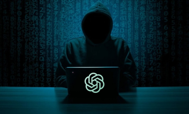 Un hacker con capucha negra y una laptop