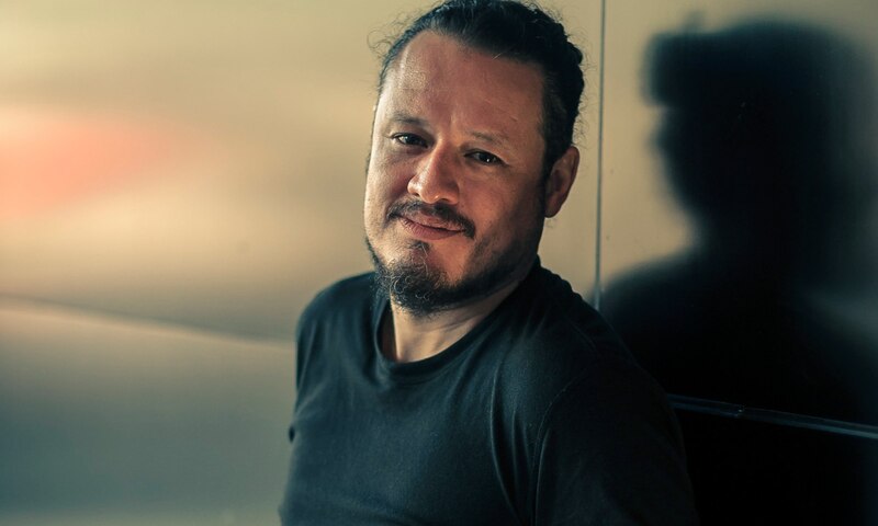 Retrato de un hombre con barba y el pelo largo recogido en un moño.
