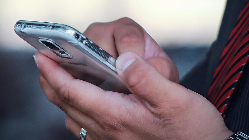 Un hombre sostiene un teléfono inteligente en la mano