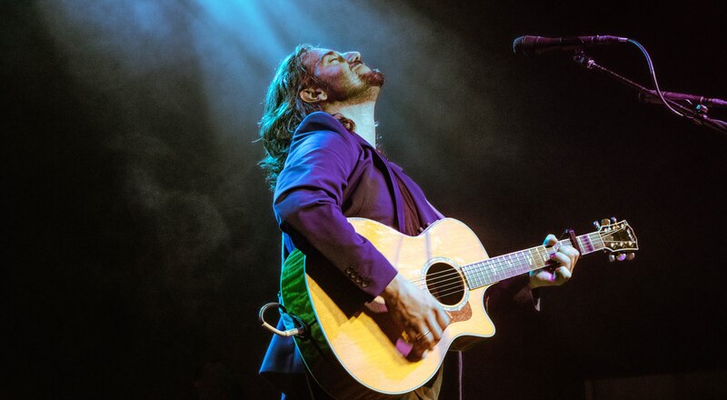 Cantante tocando la guitarra en un concierto