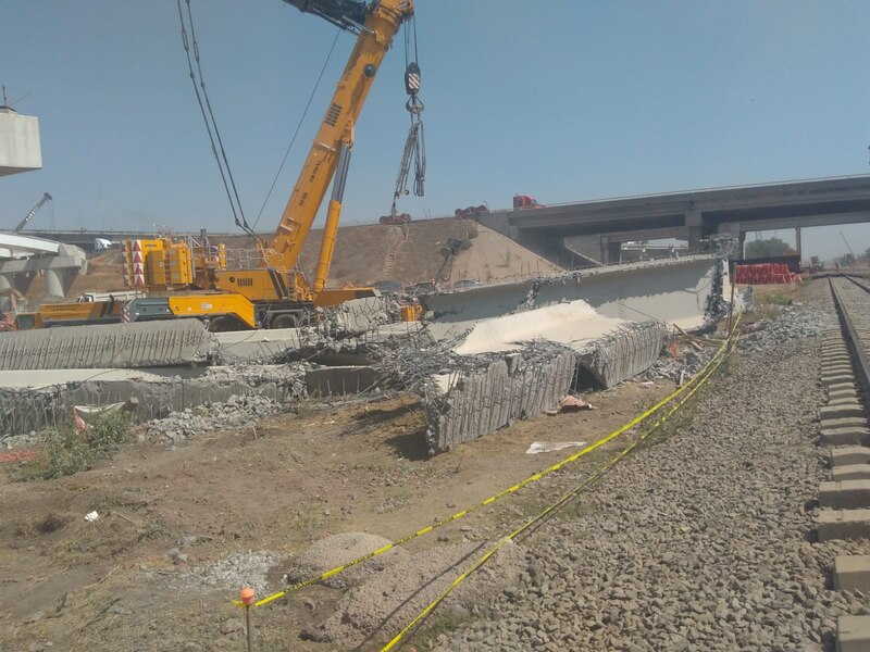 Grúa retirando escombros de un puente colapsado