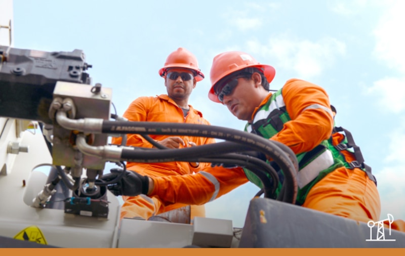 Dos trabajadores de la industria petrolera realizan tareas de mantenimiento en una plataforma petrolera.