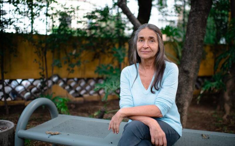 Retrato de una mujer mayor sentada en un banco en un parque
