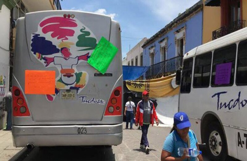 Autobús urbano con letreros pegados en la parte trasera