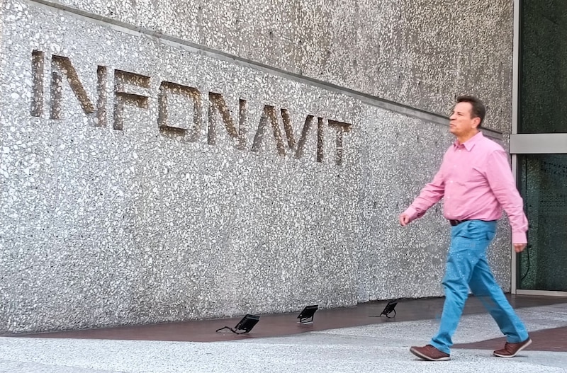 Una persona camina frente a las oficinas del Infonavit.