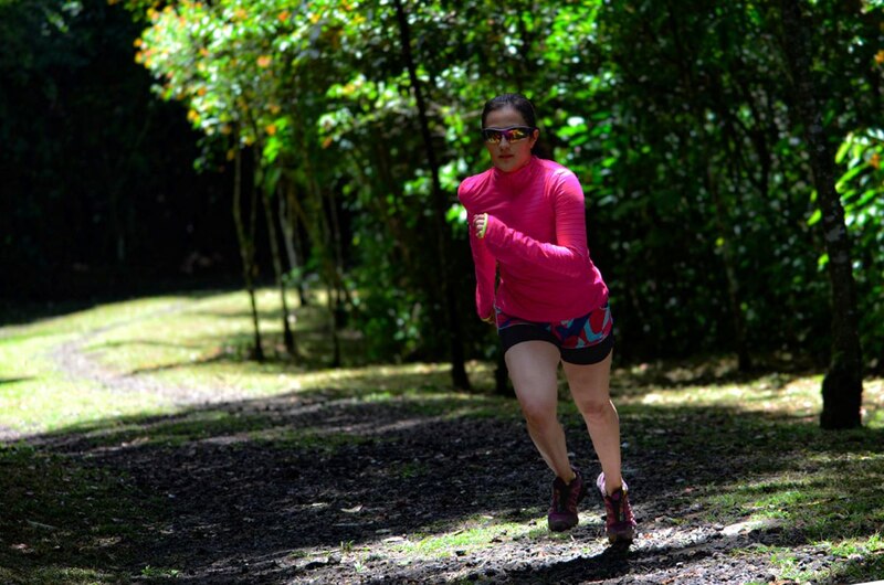 Mujer corriendo por un sendero en el bosque