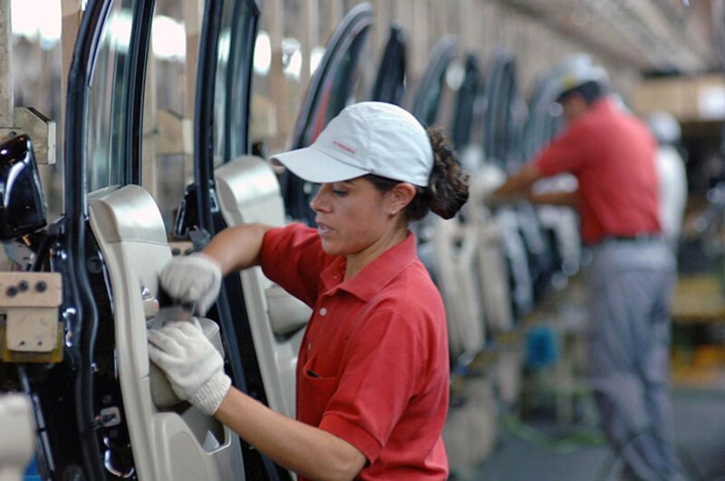 Mujer trabajando en una fábrica de automóviles