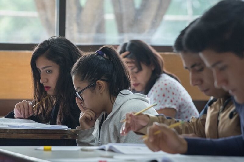 Estudiantes universitarios tomando apuntes en clase