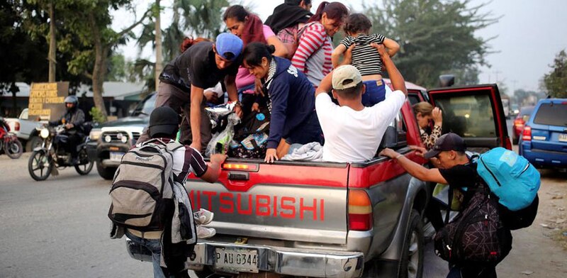 Migrantes centroamericanos viajan en la parte trasera de una camioneta en su camino hacia la frontera con Estados Unidos.