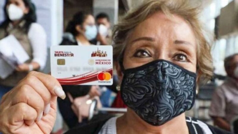 Mujer muestra su tarjeta del Bienestar