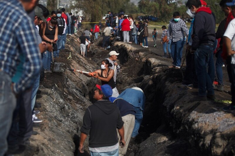 Un grupo de personas trabaja para reparar una carretera dañada